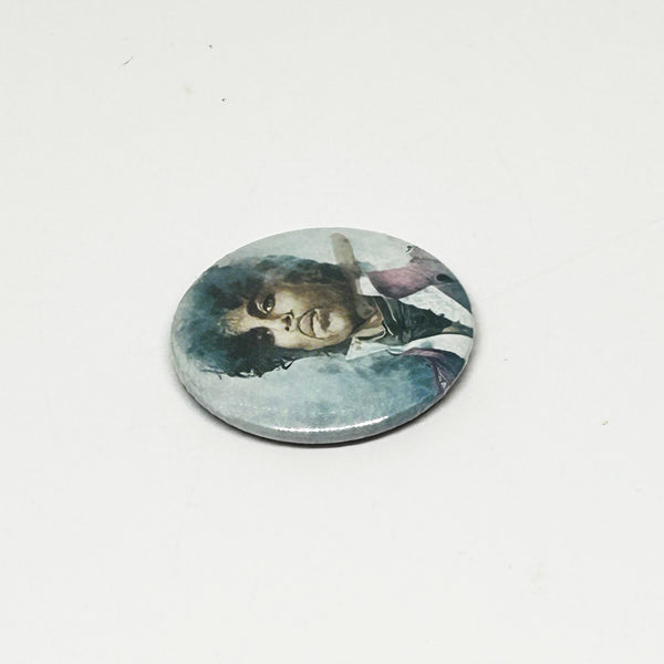 A vintage 1984 Prince pinback button badge featuring a painted portrait of Prince Rogers Nelson during the Purple Rain era