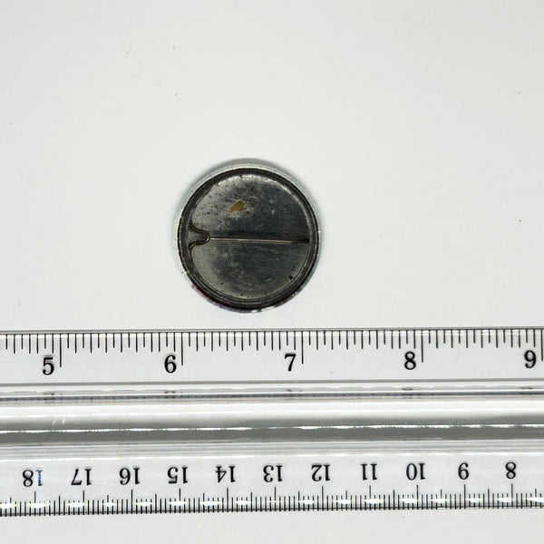 Reverse side of a vintage 1984 Prince Purple Rain pinback button badge, showing the tarnished metal back, springless wire pin mechanism, and open catch cradle on a clean white background