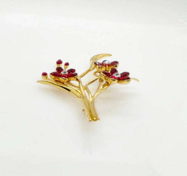 This vintage floral pin will add glamour- three blooms are exquisitely crafted of deep red marquise stones, complemented by a glistening clear rhinestone in the center. This gorgeous piece is in excellent condition and measures 3.25" tall.