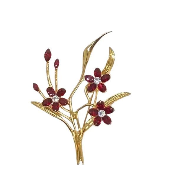 This vintage floral pin will add glamour- three blooms are exquisitely crafted of deep red marquise stones, complemented by a glistening clear rhinestone in the center. This gorgeous piece is in excellent condition and measures 3.25" tall.