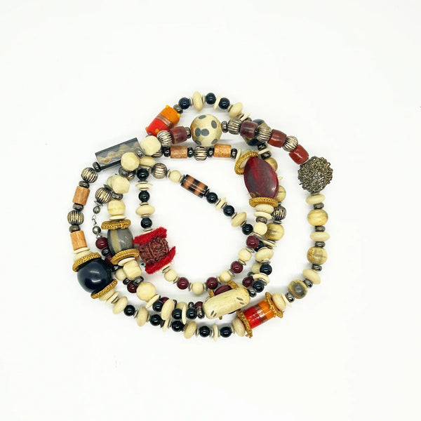 This captivating necklace is a true statement piece, boasting a unique blend of beads in an array of shapes and sizes. The earthy, nature-inspired hues create a stunning visual, with warm tones of red, black, and cream that beautifully coordinate with any fall ensemble. At nearly 60 inches in length, this adaptable infinity necklace is designed without a clasp, providing endless styling possibilities.