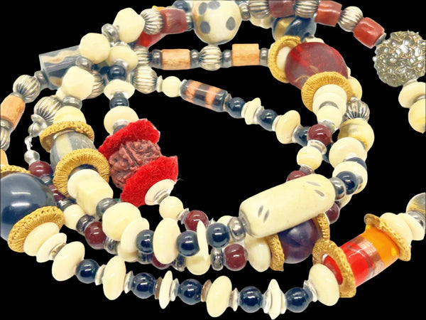 This captivating necklace is a true statement piece, boasting a unique blend of beads in an array of shapes and sizes. The earthy, nature-inspired hues create a stunning visual, with warm tones of red, black, and cream that beautifully coordinate with any fall ensemble. At nearly 60 inches in length, this adaptable infinity necklace is designed without a clasp, providing endless styling possibilities.