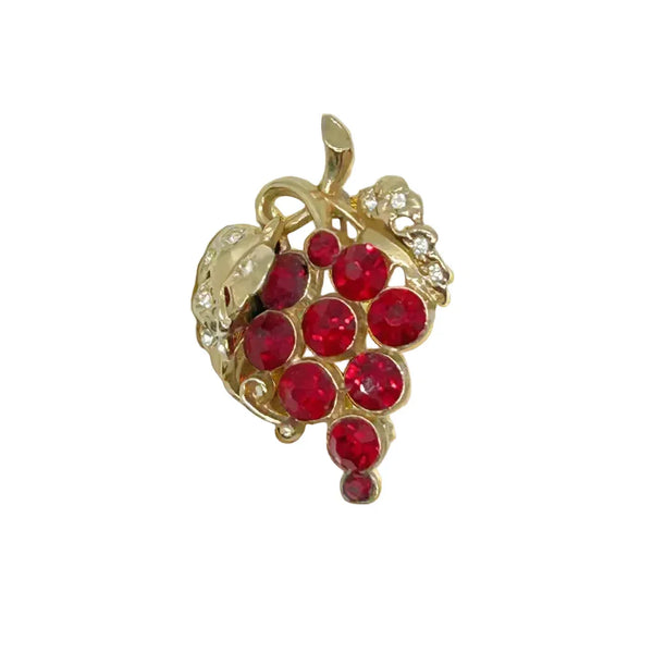 This vintage brooch is a real standout, featuring a three-dimensional cluster of red crystal or glass "grapes" and textured gold-tone leaves, with some designs including small clear accent rhinestones on the leaves. 