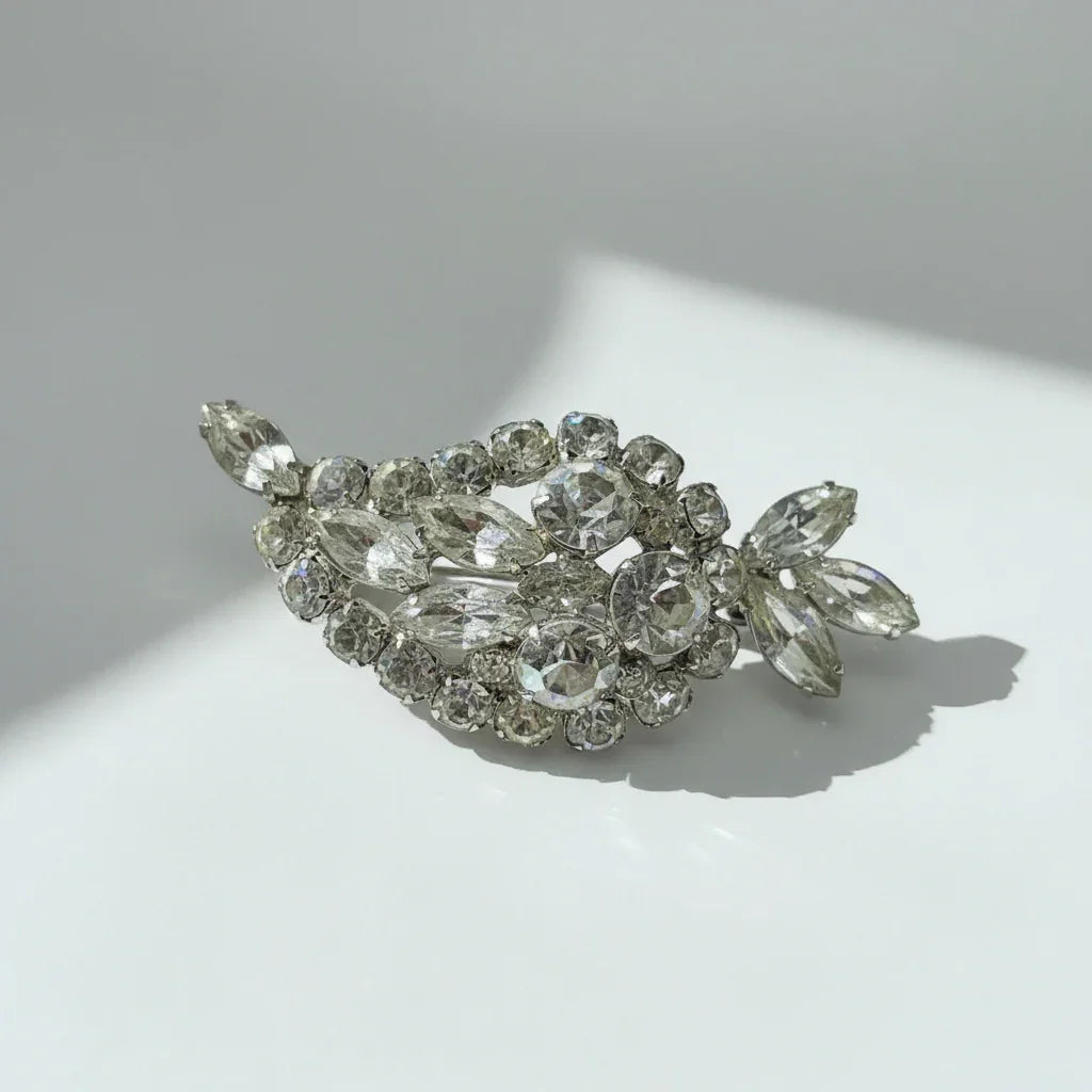 Discover this sparkling brooch featuring a large paisley shape and dazzling rhinestones. Elevate your style instantly with vintage-inspired brilliance.