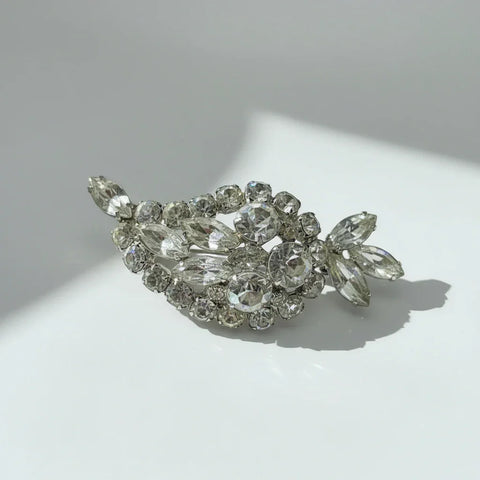 Discover this sparkling brooch featuring a large paisley shape and dazzling rhinestones. Elevate your style instantly with vintage-inspired brilliance.