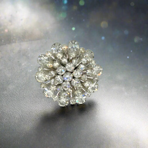 This extraordinary vintage rhinestone brooch features several layers of brilliant, round, sparking stones of varying sizes, measuring 2" across. It The back of the brooch is stunning, showcasing exquisite metalwork and reflecting its excellent condition. Add these details to make the brooch even more enticing