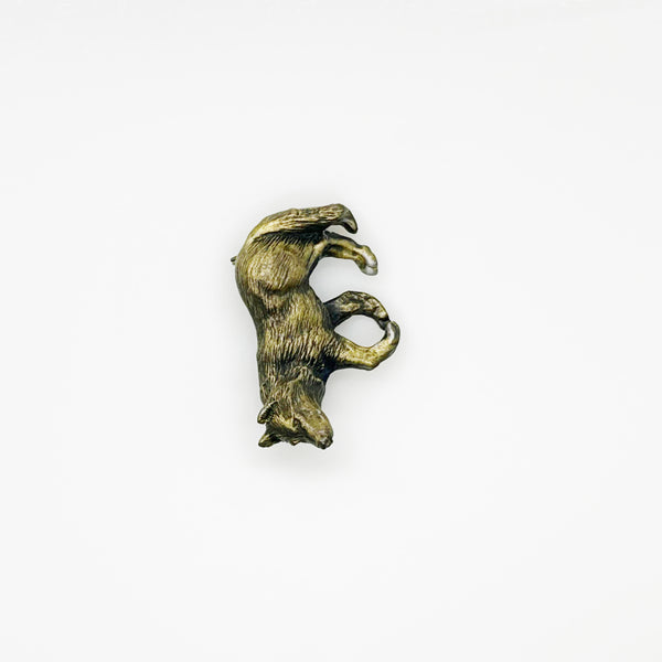 Antiqued bronze wolf brooch pin with highly detailed textured fur on a plain white background