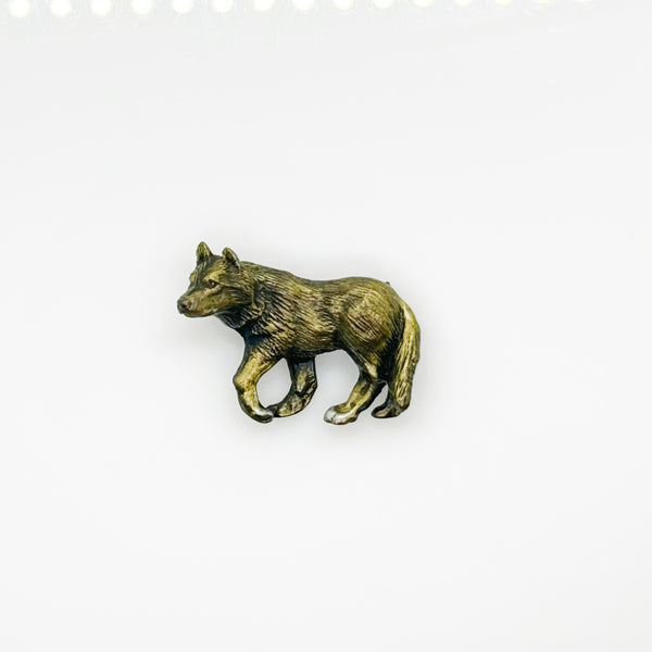 Antiqued bronze wolf brooch pin with highly detailed textured fur on a plain white background