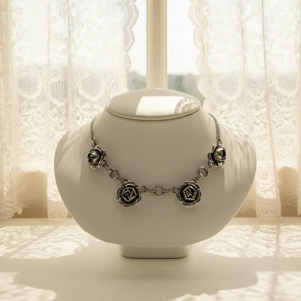 The delicate silver tone necklace boasts four stunning roses, each intricately designed and skillfully crafted. Measuring 16 inches in length, it's perfect for adding a touch of vintage elegance to any outfit and especially for a special occasion. Rest assured, this necklace is in excellent condition and ready to be worn with pride.
