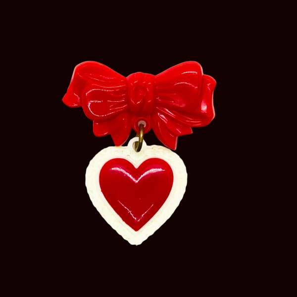 Perfect for vintage jewelry lovers: our Vintage Early Plastic Sweetheart Bow Pin provides nostalgic charm with iconic heart and bow design. Shop today!