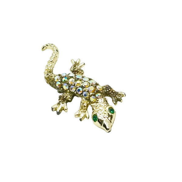 This enchanting vintage salamander brooch captures the magic of mid-century costume jewelry with its shimmering Aurora Borealis rhinestones and lustrous gold-toned setting. The iridescent body gleams with multi-colored stones that shift and dance in the light, while striking green accents highlight the creature's expressive eyes.