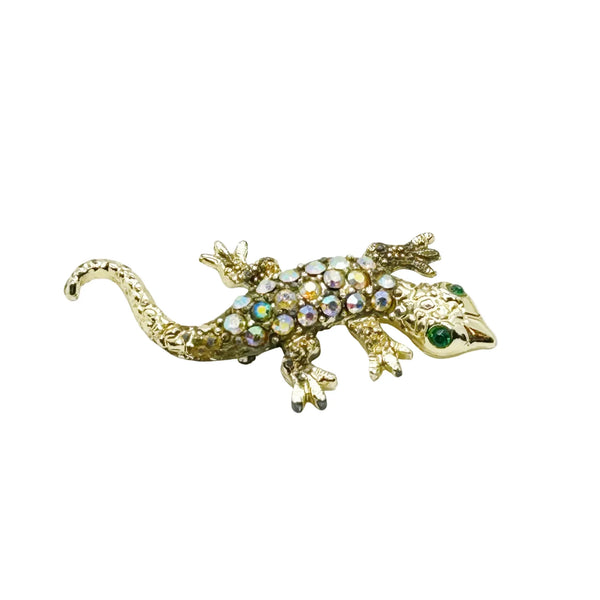 This enchanting vintage salamander brooch captures the magic of mid-century costume jewelry with its shimmering Aurora Borealis rhinestones and lustrous gold-toned setting. The iridescent body gleams with multi-colored stones that shift and dance in the light, while striking green accents highlight the creature's expressive eyes.