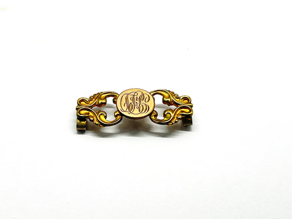 Antique Victorian monogrammed watch slide in gold-tone metal. Features a round hand-engraved monogram center and highly detailed repoussé scrollwork side accents, perfect as a jewelry making component