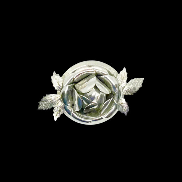 This stunning brooch features a vibrant rose as its centerpiece, surrounded by intricate petals and textured leaves. At a generous 2.25 inches, it's a striking addition to any outfit. Bring a touch of nature's beauty with you wherever you go!