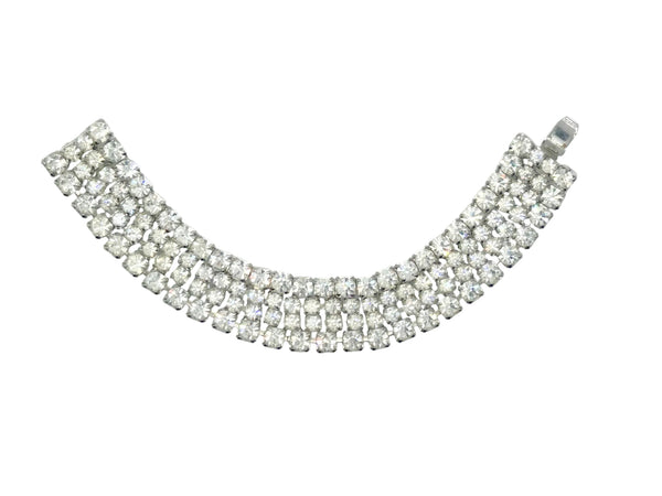This vintage rhinestone bracelet provides an elegant touch to any ensemble. Featuring four rows of meticulously prong-set rhinestones, it measures approximately 7 inches in length and 0.75 inches in width. 