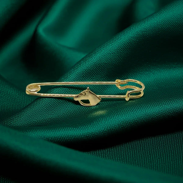 This exquisite gold-tone horse head brooch is perfect for adorning blouses, kilts, or skirts with equestrian elegance. This sophisticated accessory, measuring .25" wide by 2.5" long, presents in impeccable near-mint condition.