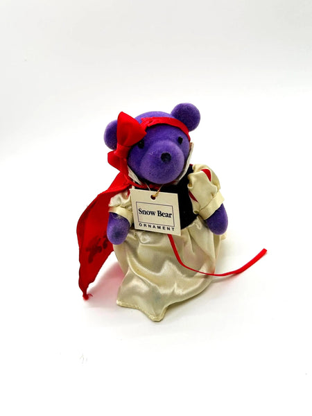 A small, purple plush bear ornament dressed as Snow White. 