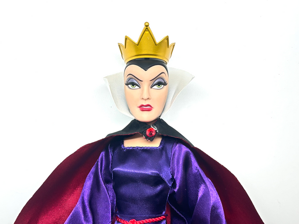 A vintage-style Evil Queen doll with a gold crown, purple gown, and red cape, photographed against a plain white background.