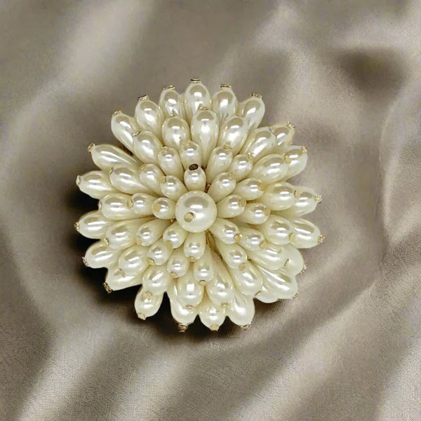 This exquisite flower brooch exudes elegance, featuring stunning faux teardrop pearls set on a captivating gold tone metal frame measuring 2.75” in diameter. It looks like a luxe chrysanthemum. 