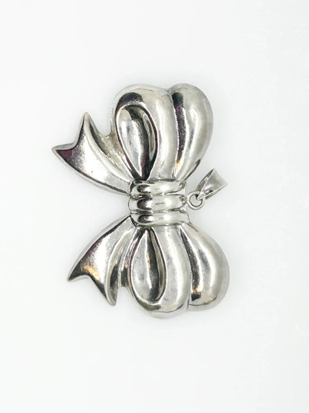 Experience the elegance of our Vintage Sterling Silver Bow Pendant/Brooch. Featuring a beautifully puffed, hollow design, this accessory brings refined style to your wardrobe. Measuring a striking 2.5 inches, it is marked with a 925 stamp on the reverse and equipped with a secure pin closure for effortless wear