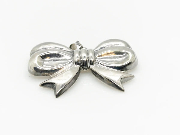 Experience the elegance of our Vintage Sterling Silver Bow Pendant/Brooch. Featuring a beautifully puffed, hollow design, this accessory brings refined style to your wardrobe. Measuring a striking 2.5 inches, it is marked with a 925 stamp on the reverse and equipped with a secure pin closure for effortless wear