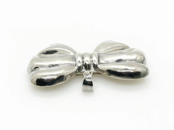 Experience the elegance of our Vintage Sterling Silver Bow Pendant/Brooch. Featuring a beautifully puffed, hollow design, this accessory brings refined style to your wardrobe. Measuring a striking 2.5 inches, it is marked with a 925 stamp on the reverse and equipped with a secure pin closure for effortless wear