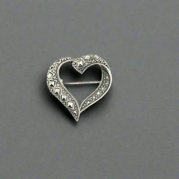 Make a statement with this unique vintage heart brooch crafted from genuine Sterling silver. Be enchanted by the intricate metal work beading and diamond-shaped marcasites, giving it a timeless and elegant look.