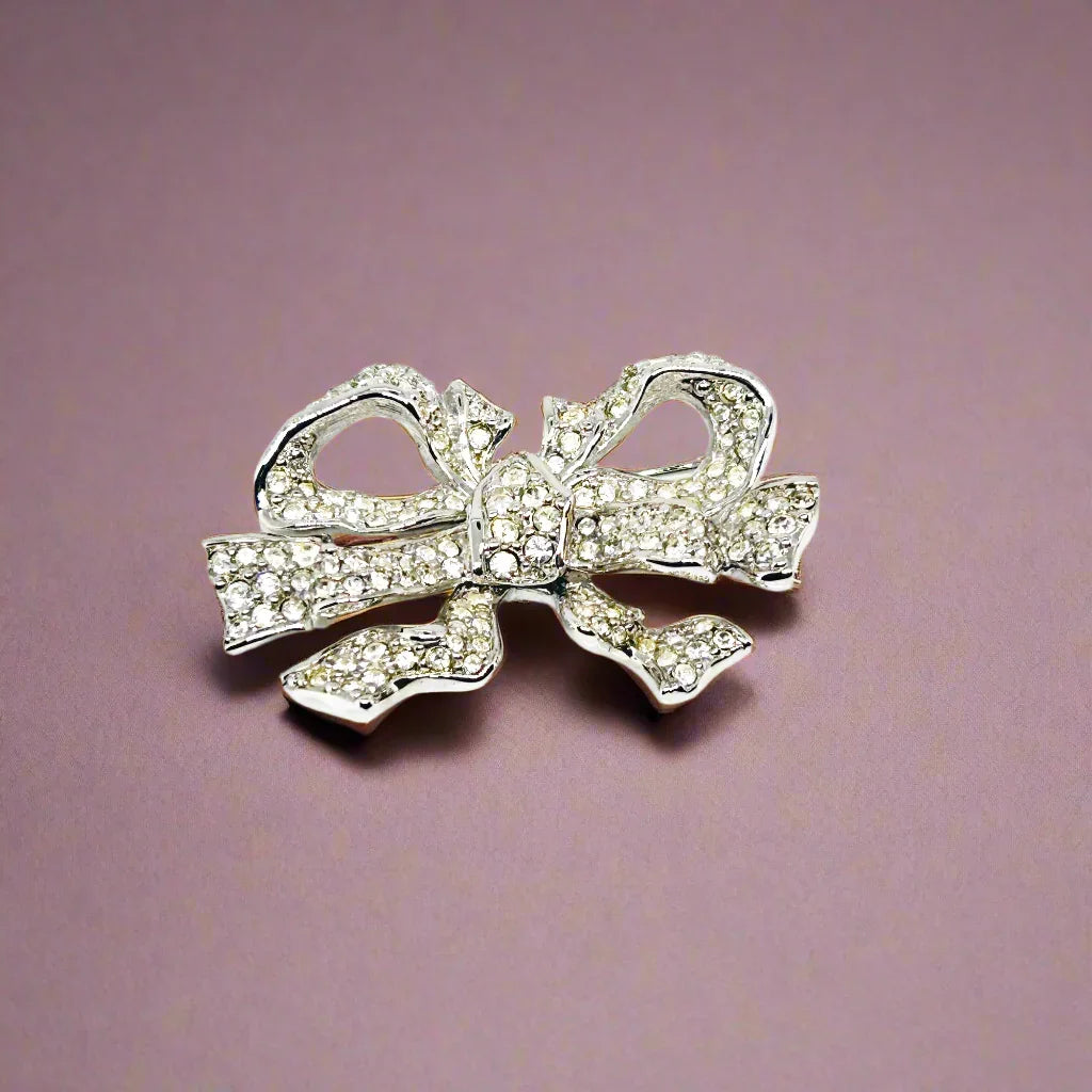 Measuring precisely 1.75 inches, this stunning brooch is meticulously crafted with a rhodium setting and proudly bears the Swarovski signature swan. Every pave-set cryatal stone is present and radiates with captivating brilliance, ensuring this brooch will be a treasured addition to your collection for years to come