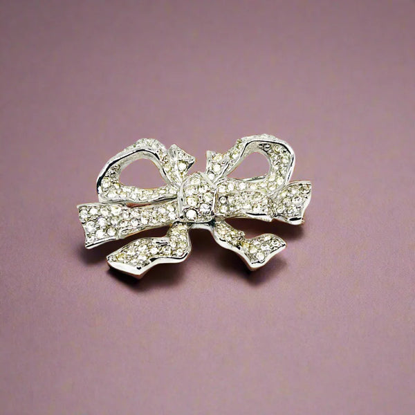 Measuring precisely 1.75 inches, this stunning brooch is meticulously crafted with a rhodium setting and proudly bears the Swarovski signature swan. Every pave-set cryatal stone is present and radiates with captivating brilliance, ensuring this brooch will be a treasured addition to your collection for years to come