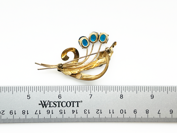Perfect for vintage lovers: our Striking Gold Filled Oval Teal Blue Vintage Flower Spray Brooch provides timeless charm with bold teal stones. Shop today!