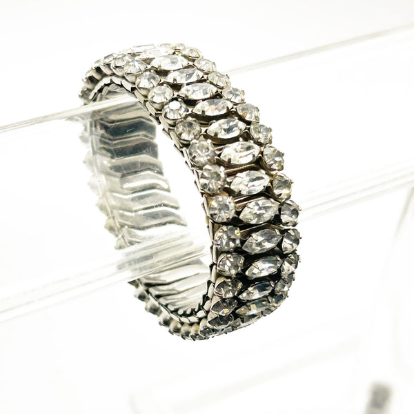 Sparkle up your vintage jewelry collection with this stunning three-row rhinestone bracelet expansion bracelet. Crafted in the classic style beloved from the 1940s through 1960s, this piece showcases brilliant clear glass rhinestones secured in a flexible silver-tone metal band. 