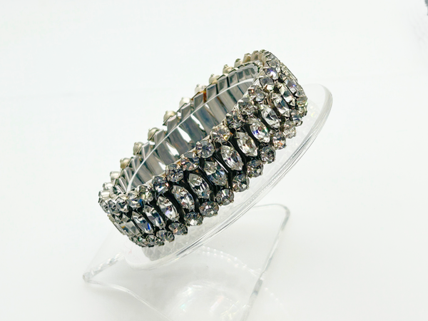 Sparkle up your vintage jewelry collection with this stunning three-row rhinestone bracelet expansion bracelet. Crafted in the classic style beloved from the 1940s through 1960s, this piece showcases brilliant clear glass rhinestones secured in a flexible silver-tone metal band. 