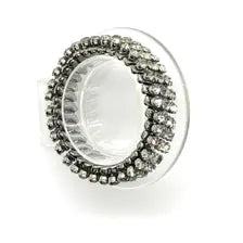 Three-row vintage rhinestone expansion bracelet with small, faceted stones set in a silvertone accordion-style stretch band, shown resting at an angle on a clear display stand against a white background