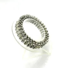 A close-up studio shot of a vintage silver-tone rhinestone expansion bracelet, featuring three rows of prong-set clear gemstones on a flexible, metallic accordion-style expansion band, shown against a plain white background