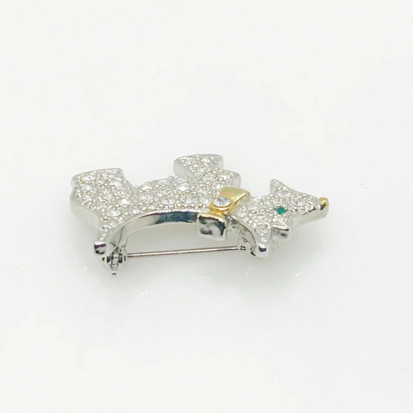 This brooch may be small in size, but is big on sparkle. Add a dash of canine charm to your outfit with this adorable vintage terrier brooch! This pint-sized pup brings major bling factor with its dazzling coat of pave set white rhinestones that catch the light with every movement. With its cheerful green eye that seems to wink at admirers, this petite (1.5" across) pin brings personality to any ensemble.