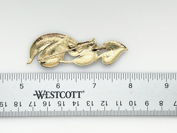 This stylish Trifari brooch features three black enamel leaves and gold-tone metal accents. Dating from the 1980s-1990s, it's part of Trifari's well-documented series of black enamel and gold-tone leaf brooches. 