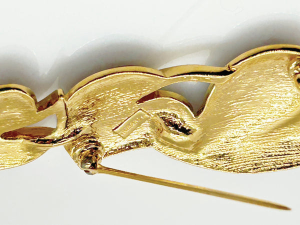 This stylish Trifari brooch features three black enamel leaves and gold-tone metal accents. Dating from the 1980s-1990s, it's part of Trifari's well-documented series of black enamel and gold-tone leaf brooches. 