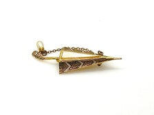 Vintage Spanish Damascene umbrella brooch with gold-tone filigree canopy panels, detailed red and black enamel patterns, a triangular mother of pearl inlay, and a dangling gold chain with a teardrop faux pearl charm against a plain white background