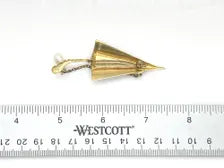Vintage Spanish Damascene umbrella brooch with gold-tone filigree canopy panels, detailed red and black enamel patterns, a triangular mother of pearl inlay, and a dangling gold chain with a teardrop faux pearl charm against a plain white background
