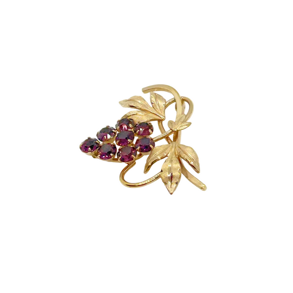 Vintage Van Dell grape cluster brooch featuring prong-set purple rhinestones hanging from a 12kt gold-filled vine with textured leaves on a clean white background