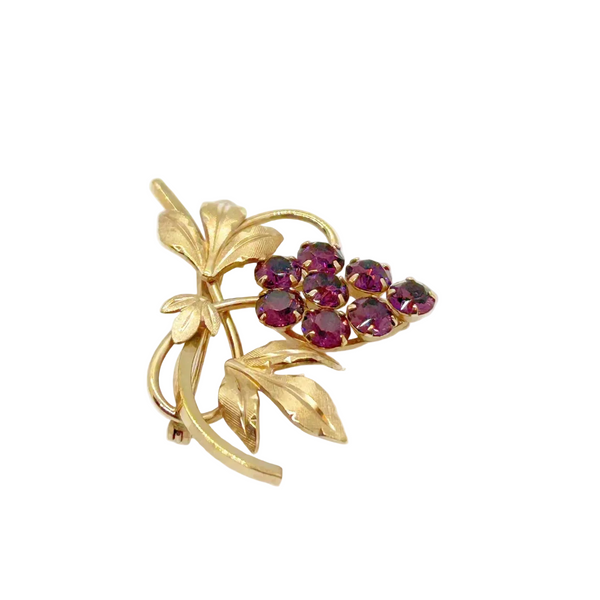 Vintage Van Dell grape cluster brooch featuring prong-set purple rhinestones hanging from a 12kt gold-filled vine with textured leaves on a clean white background