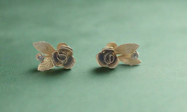 Elevate your look with vintage rose earrings featuring a detailed golden rose and rhinestone. Secure screw-back ensures comfort. Perfect rose bloom earrings.