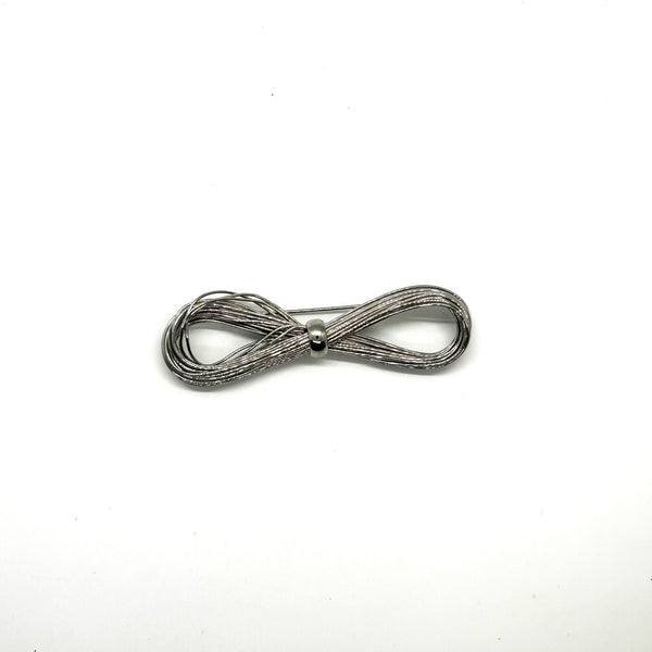 A silver-toned multi-strand wire bow brooch, featuring an infinity-shaped loop silhouette cinched with a smooth central band, displayed against a plain white background.