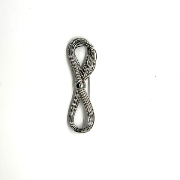 A silver-toned multi-strand wire bow brooch, featuring an infinity-shaped loop silhouette cinched with a smooth central band, displayed against a plain white background.