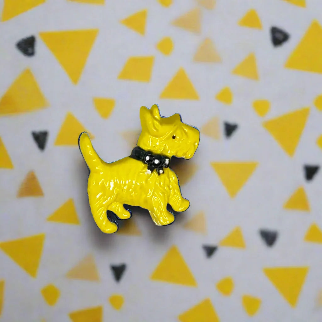 Discover a captivating vintage brooch from the 1930s showcasing a charming yellow Scottie dog adorned with a fashionable black and white polka dot bow tie. At about 1.25 inches wide, this delightful accessory brings a bit of retro charm and elegance to your wardrobe. 