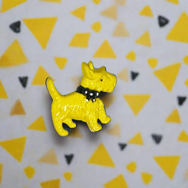 Discover a captivating vintage brooch from the 1930s showcasing a charming yellow Scottie dog adorned with a fashionable black and white polka dot bow tie. At about 1.25 inches wide, this delightful accessory brings a bit of retro charm and elegance to your wardrobe. 